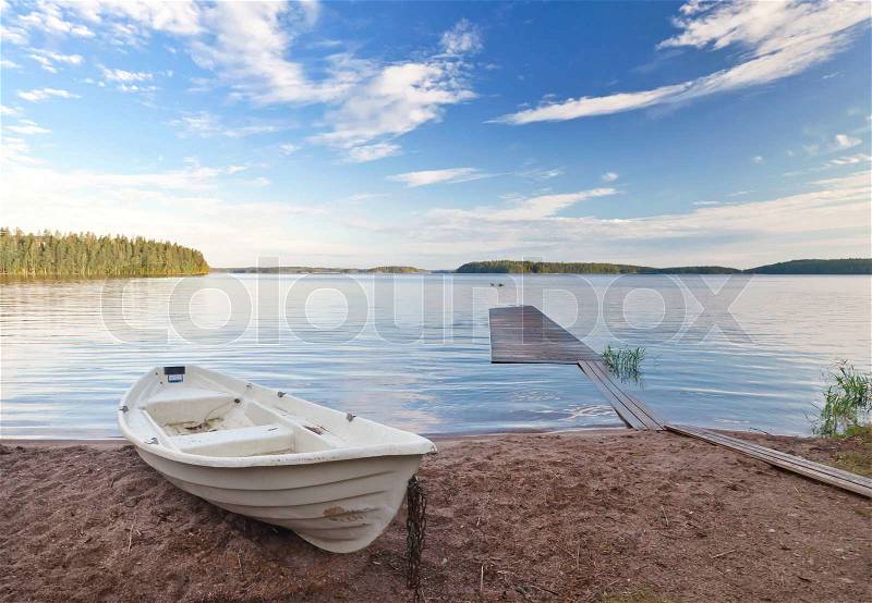 Coastal landscape with old white boat on the coast of Saimaa lake, Finland, stock photo