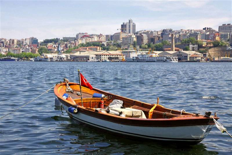 Fishing boat on the Golden Horn Gulf with Istanbul downtown, Turkey, stock photo