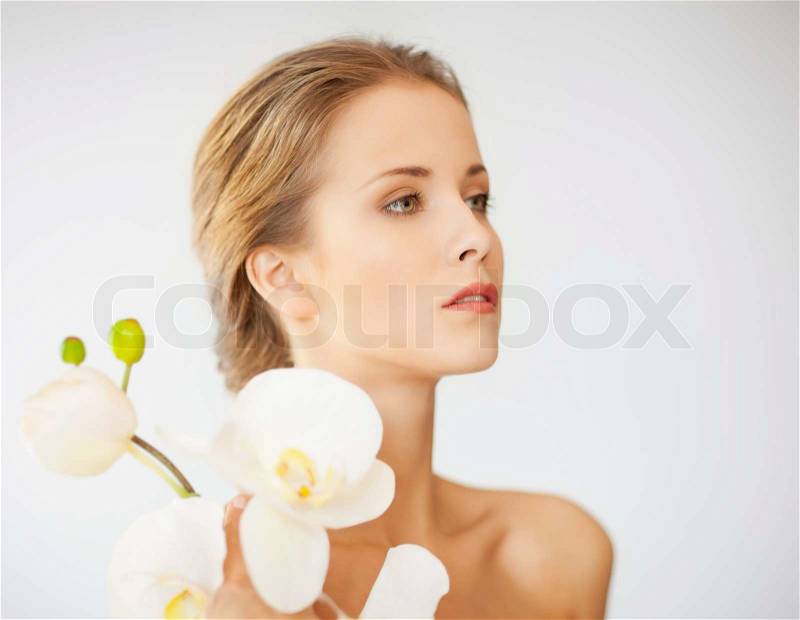 Lovely woman with orchid flower, stock photo