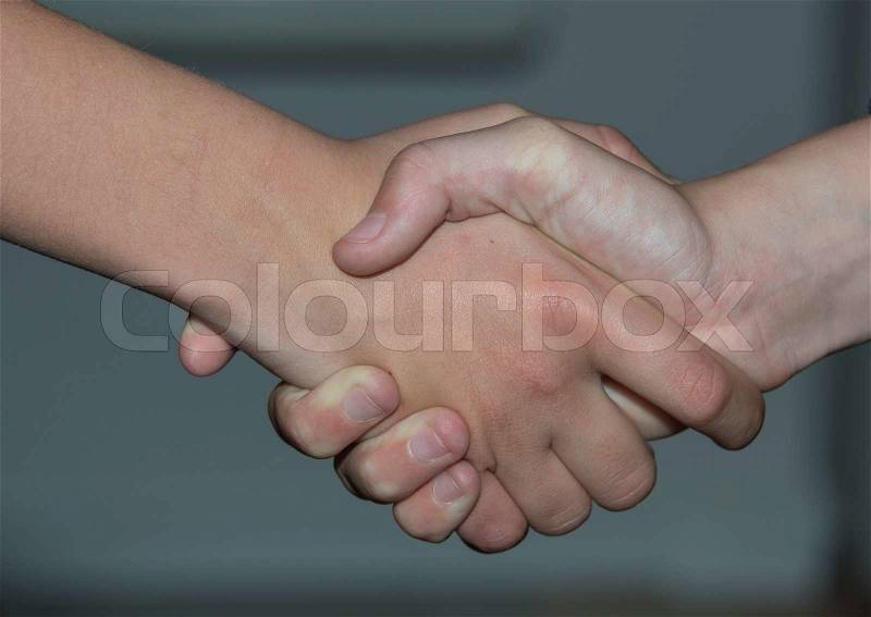 Two friends shake hands, stock photo