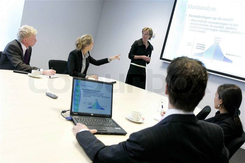 Business people discussing a graphic on a screen, stock photo