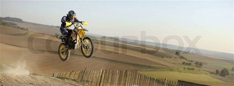 Moto crosser jumping on a hill in france, stock photo