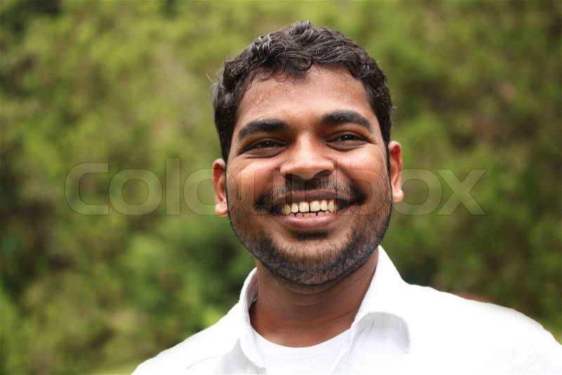 Close-up image of happy, smiling & smart south-asian/indian entrepreneur with satisfied expression The person is wearing a white shirt & the picture is shot in natural settings, stock photo
