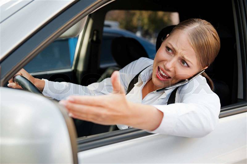 Angry female driving the car, stock photo
