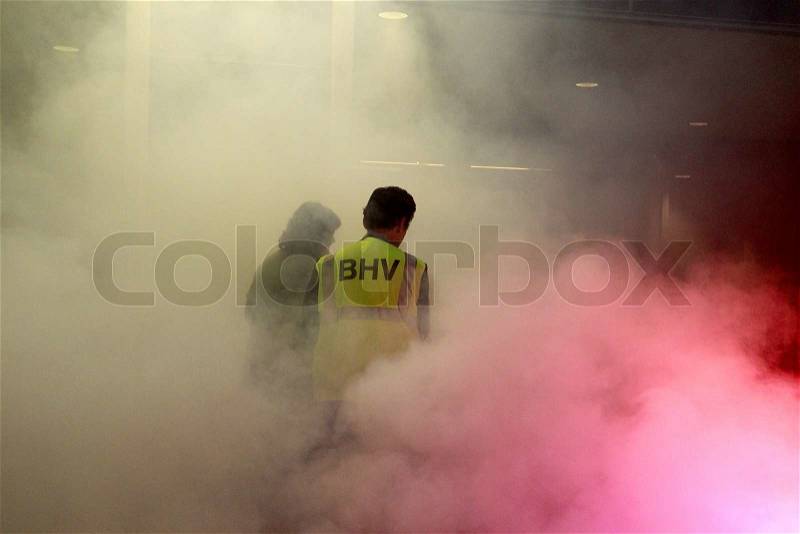 Company safety officer guiding a victim in a burning building, stock photo
