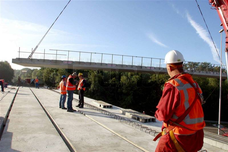 Construction workers placing a section of a new viaduct, stock photo