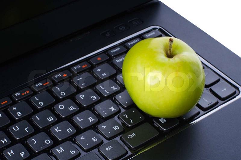 Apple on laptop keyboard, stock photo