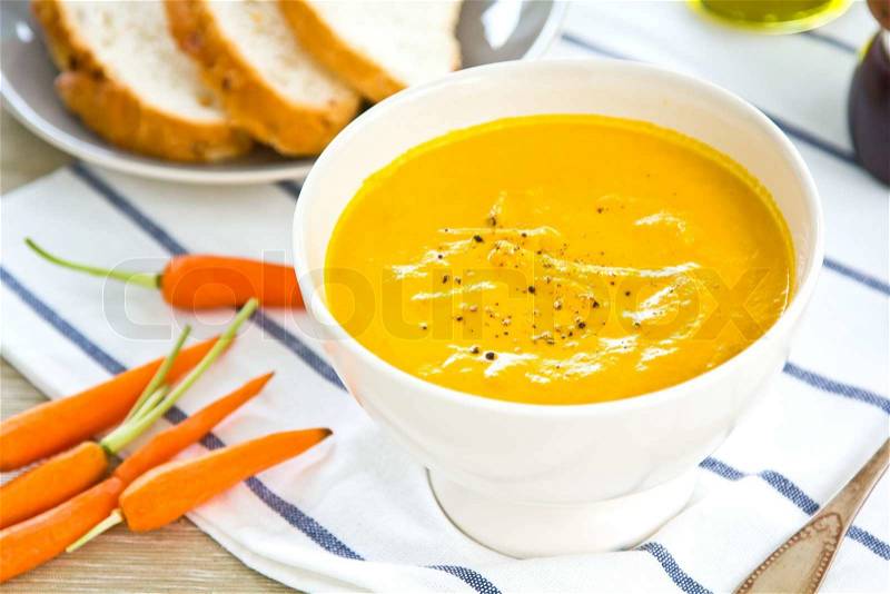 Carrot soup by some pieces of bread, stock photo