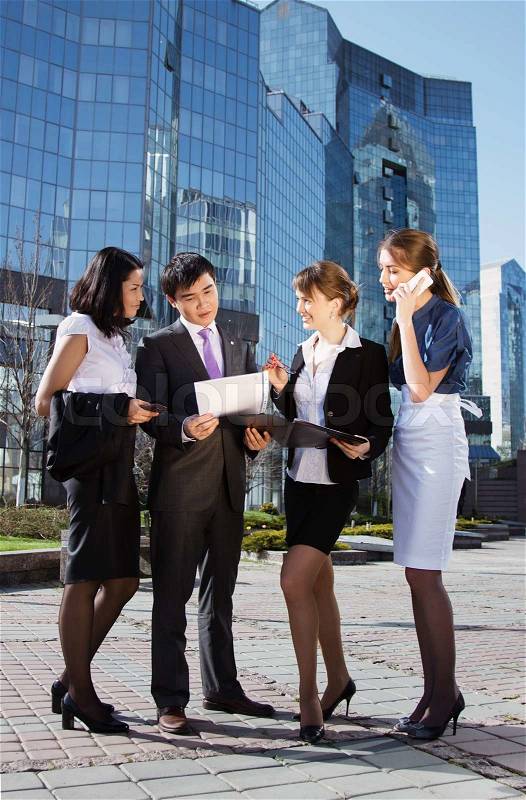 Group of business people meeting outdoor in front of office building, stock photo