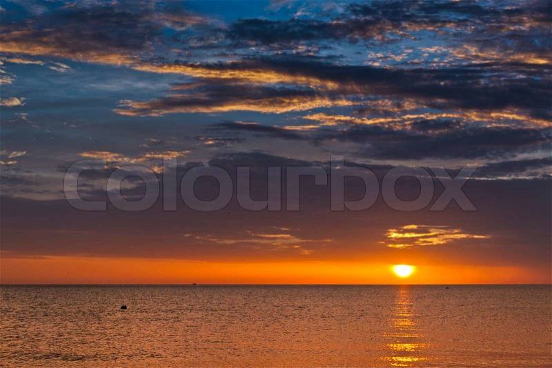 Dramatic sunset sky with clouds over ocean, stock photo