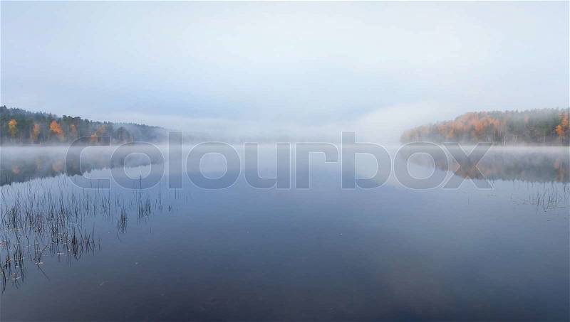 Still lake autumn panoramic landscape in cold foggy morning, stock photo