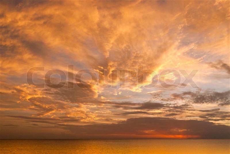 Dramatic sunset sky with clouds over ocean, stock photo