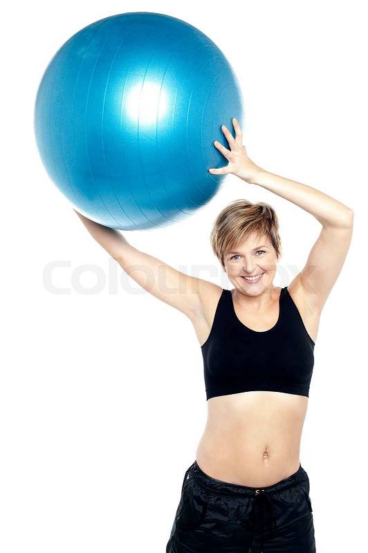 A healthy woman lifting big swiss ball, stock photo