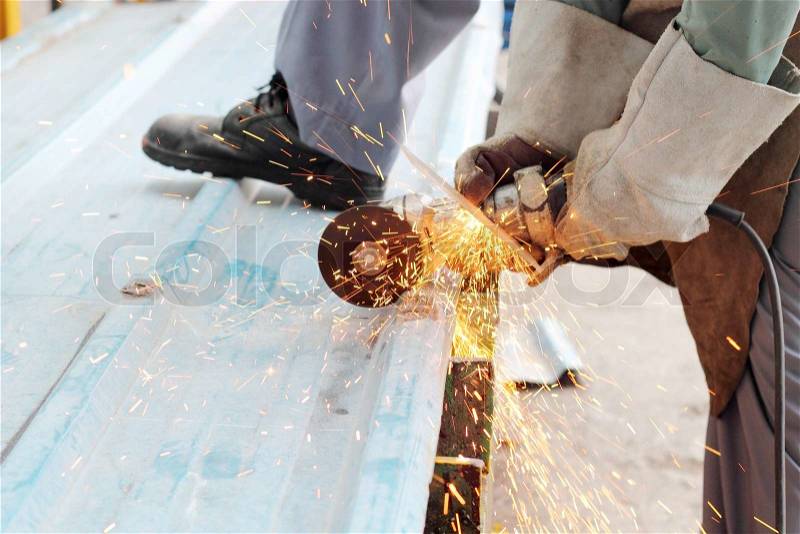 Industrial worker make a spark by cut the metal sheet by grinders, stock photo