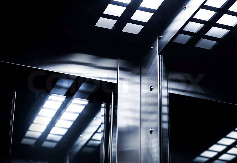 Abstract modern dark interior fragment with shining steel and mirrored glass, stock photo