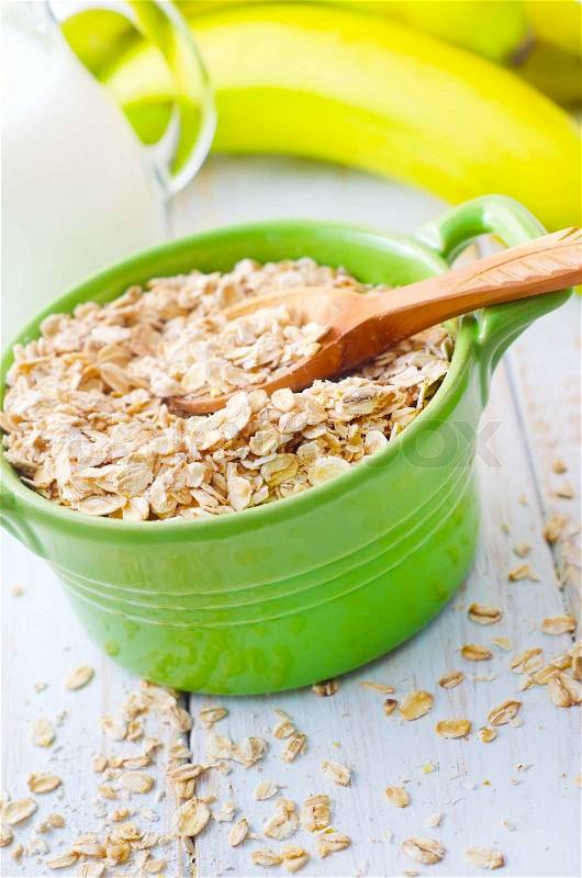 Oat flakes in the green bowl with banana and milk, stock photo
