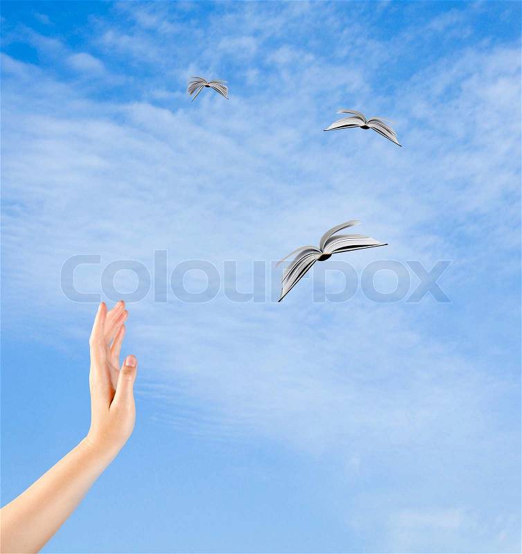 Books flying from hand, stock photo