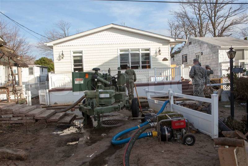 NEW YORK -November12: US Army helping Hurricane Sandy victims move a debris and parts of destroyed houses in the Breezy Point on November 12, 2012 in the Queens,NY, stock photo