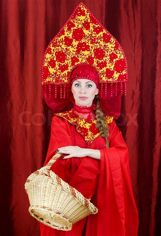Woman in russian traditional clothes with basket, stock photo