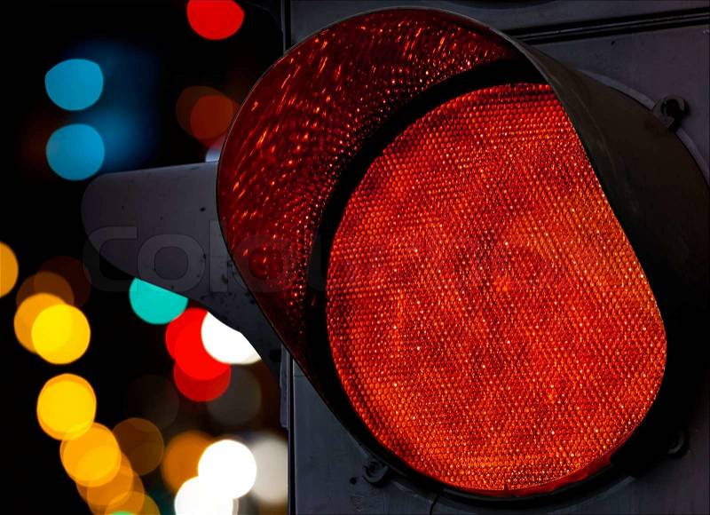 Red traffic light with colorful unfocused lights on a background, stock photo