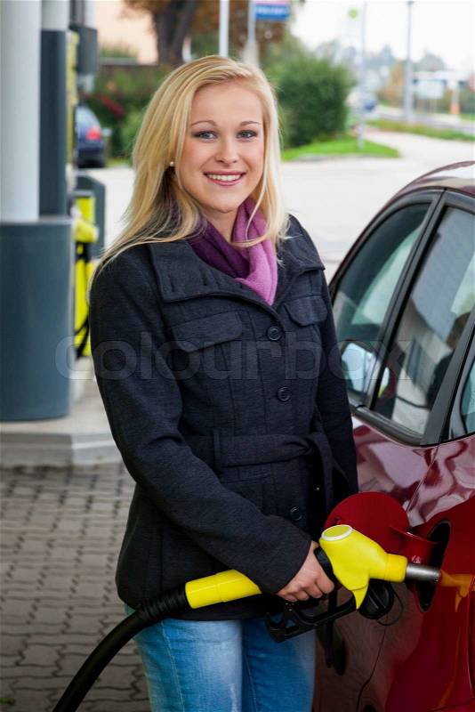 Woman at gas station to refuel, stock photo