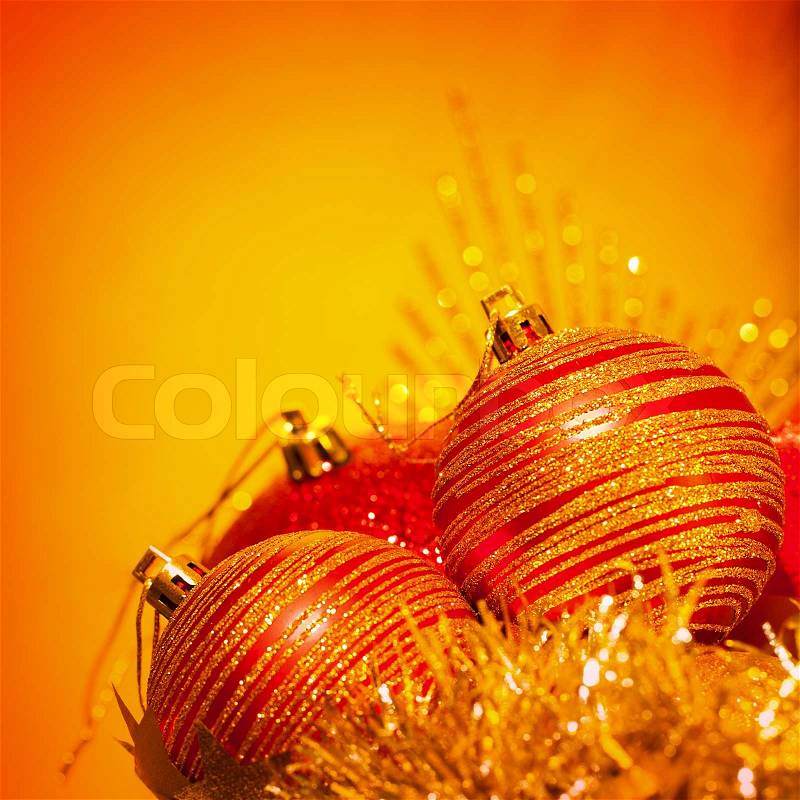 Image of red Christmas bubbles border, festive decorations isolated on orange background, golden holiday ornaments, beautiful greeting card, New Year still life, traditional xmas decor, stock photo
