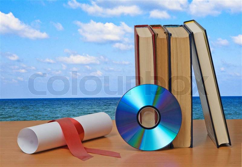 Scroll with red ribbon and books, stock photo