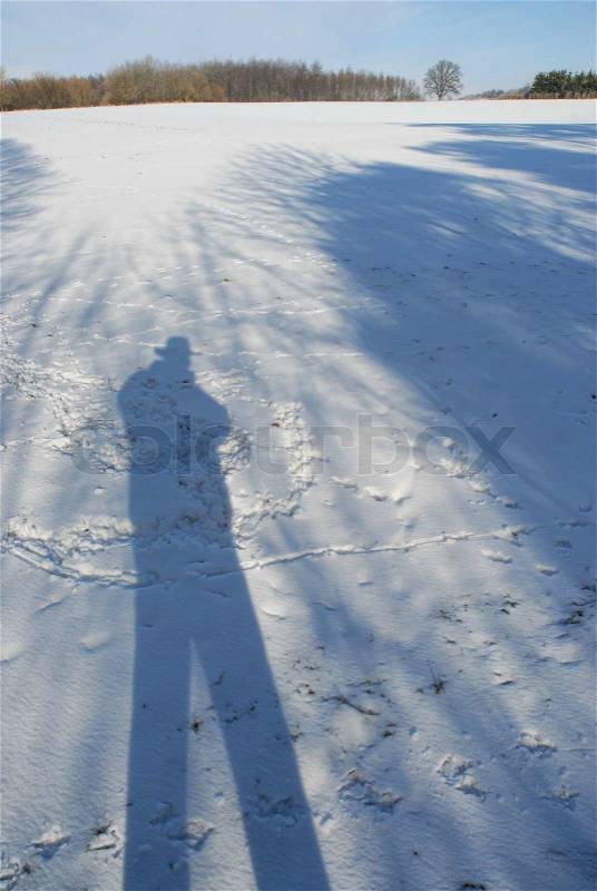 Shadow of a man in the snow, stock photo