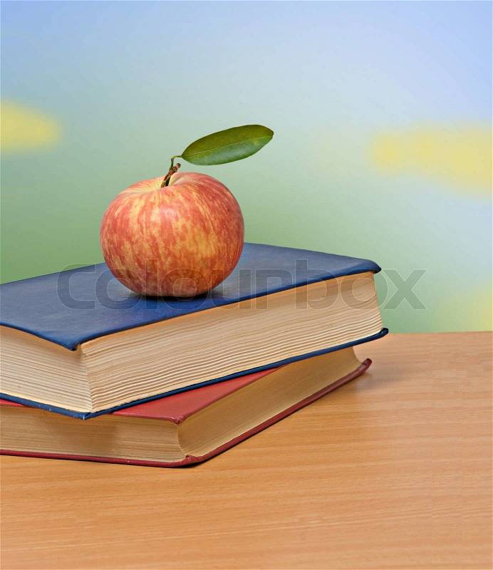 Red apple and books on desk, stock photo