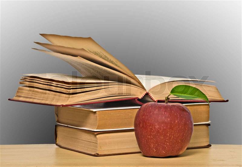 Red apple and books on desk, stock photo