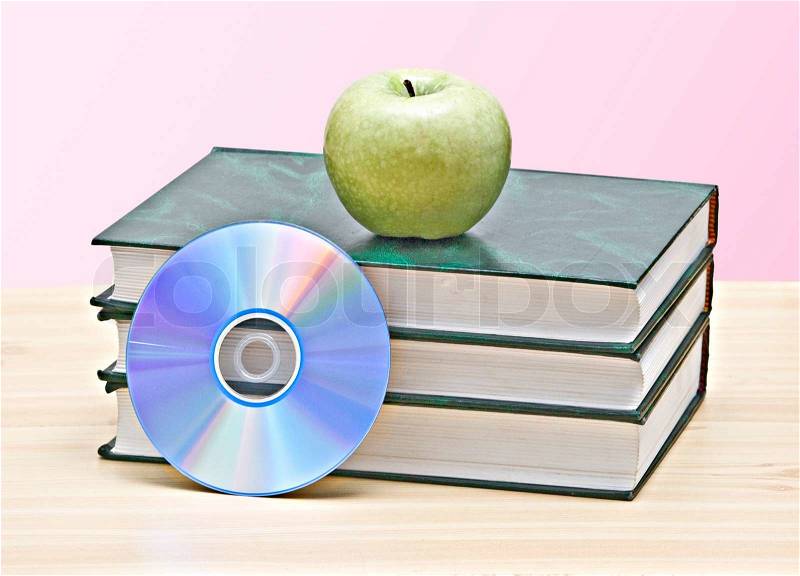 Apple, dvd, and books as a symbol of transition from old to new ways of learning, stock photo