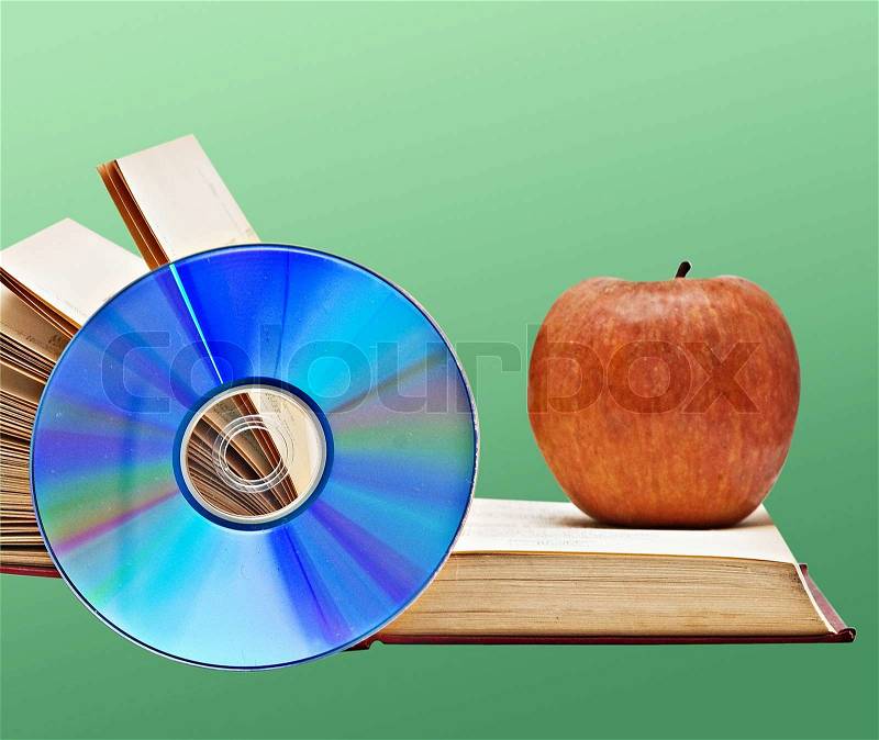 Apple, dvd, and books as a symbol of transition from old to new ways of learning, stock photo