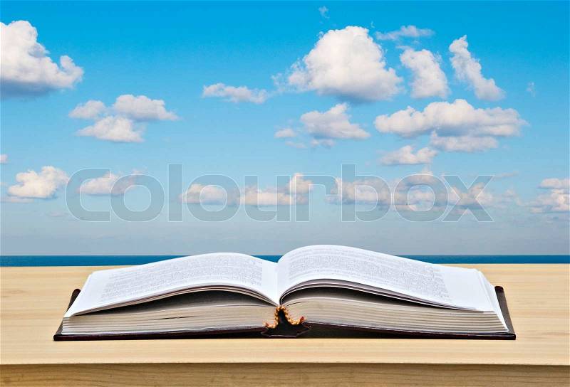 Open book on desk and sea, stock photo
