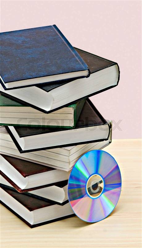 Pile of booksand DVD disk as symbols of old and new methods of information storage, stock photo