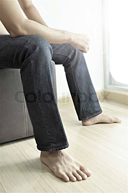 Man wearing jeans sitting on stool, stock photo