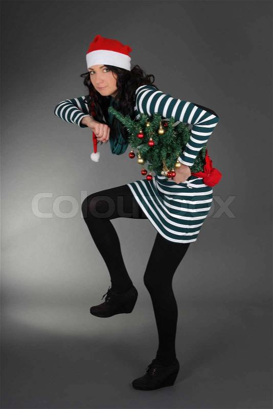 Woman in santa hat with christmas tree, stock photo