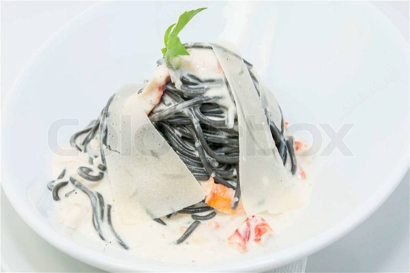 Black spaghetti with white sauce with cheese, stock photo
