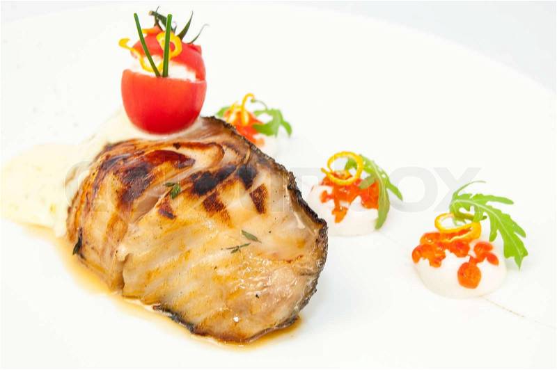 Roasted fillet of grilled fish in a white sauce, stock photo