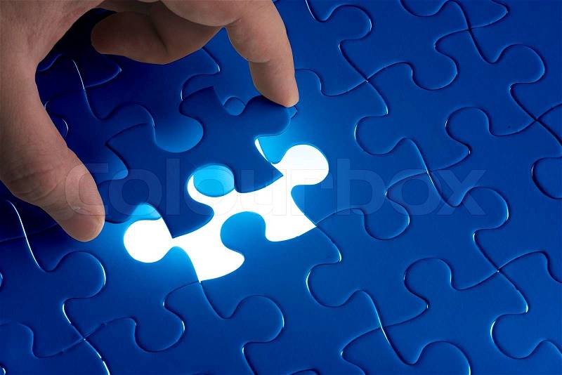 Missing jigsaw puzzle piece with light glow, business concept for completing the final puzzle piece, stock photo
