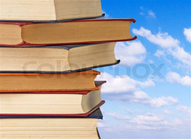 Pile of books on sky background, stock photo