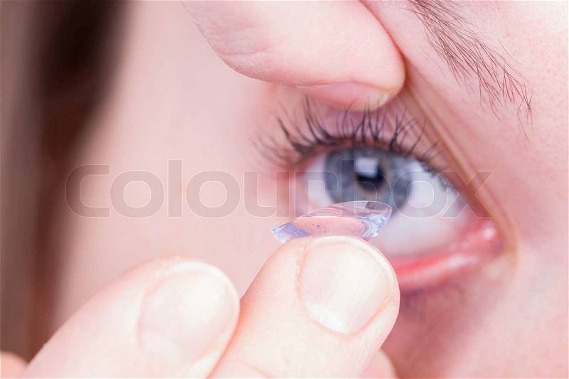 Close up of inserting a contact lens, stock photo