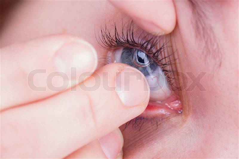 Close up of inserting a contact lens, stock photo