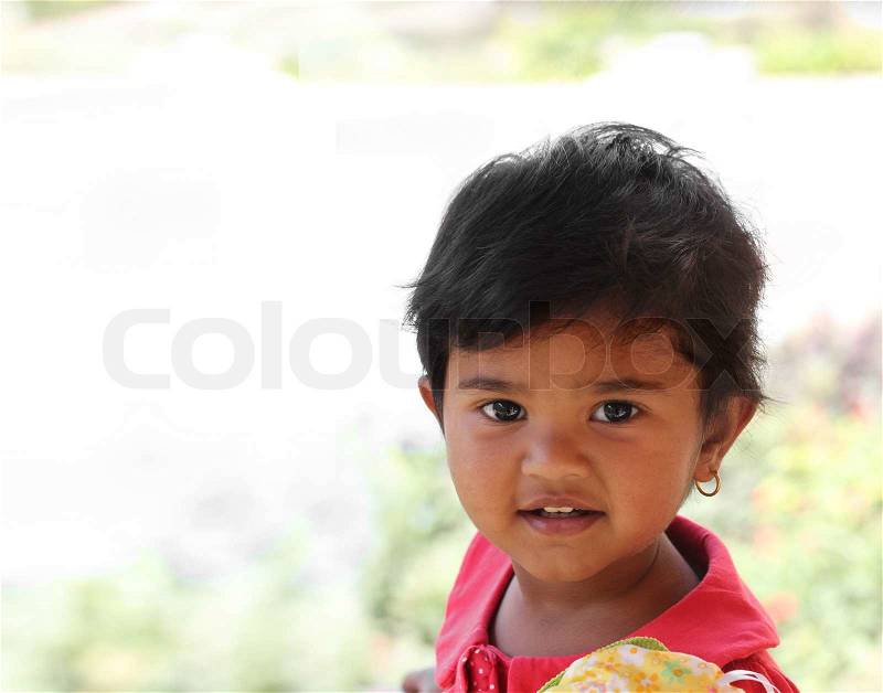 Photo of pretty and happy indian girl child with curious but satisfied expression on the face And also with toddler\'s innocence and a beautiful smile The child is of pre school/kinder-garten age, stock photo