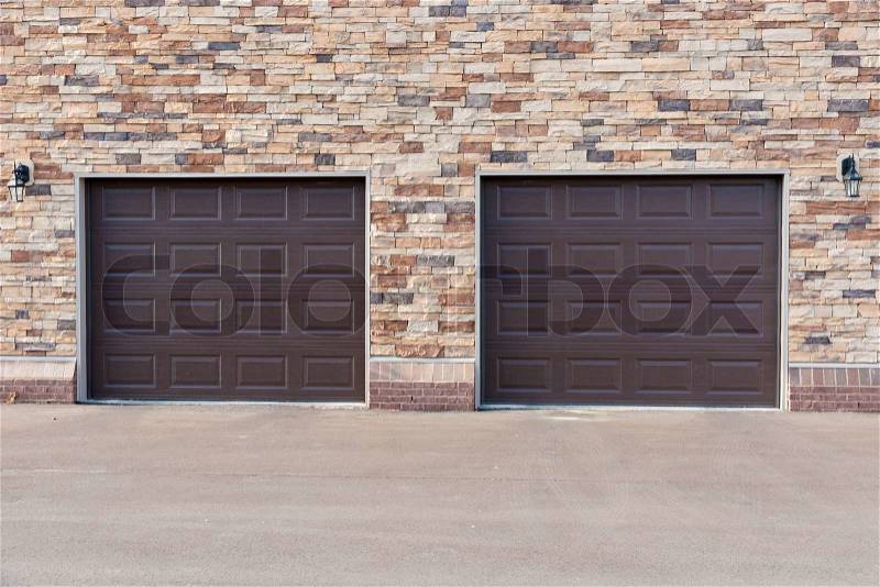 Two garage doors on brick wall, stock photo