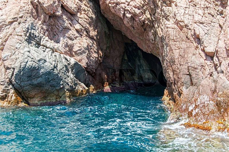 Entrance to sea cave on shoreline of Costa Brava Catalonia, stock photo