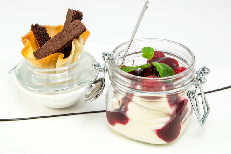 Raspberry cream dessert in a glass jar, stock photo