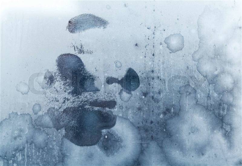 Male face print on frozen windows glass, stock photo