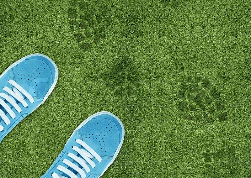 Shoe print on green grassland, stock photo