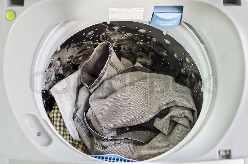 Dirty clothes in washing machine, stock photo