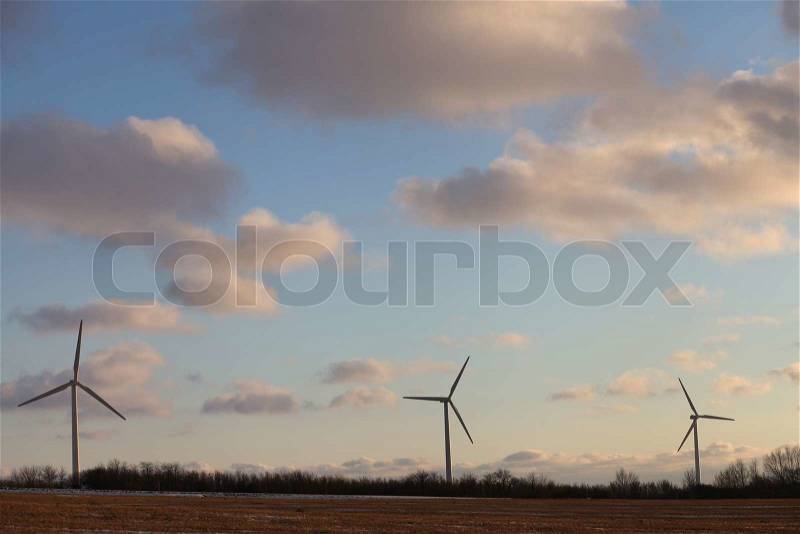 3 wind turbines silhouette against clouded sky Denmark, stock photo
